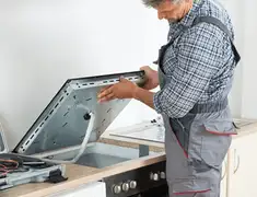 Appliance repair technician installing a built-in cooktop in Chattanooga, TN