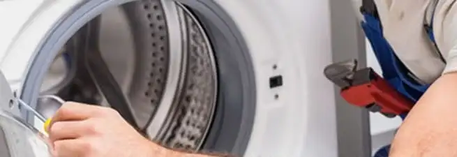 Appliance technician repairing a clothes dryer drum and internal parts in Chattanooga, TN