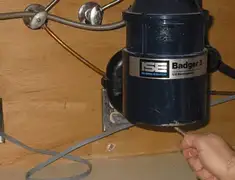 Garbage disposal repair technician tightening the mounting ring under a sink in Chattanooga, TN