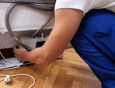 Appliance repair technician fixing refrigerator water line and connections in Chattanooga, TN