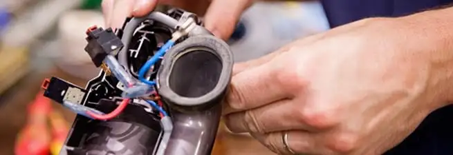 Vacuum repair technician reconnecting wiring and components in Chattanooga, TN
