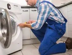 Washing machine repair technician servicing a front-load washer in Chattanooga, TN