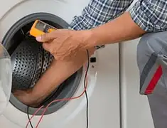 Washing machine repair technician testing a front-load washer with diagnostic tools in Chattanooga, TN