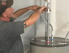 Water heater repair technician tightening supply line connections in Chattanooga, TN