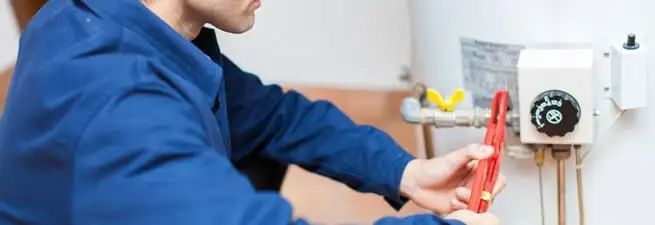Water heater repair technician adjusting the temperature control and gas valve in Chattanooga, TN